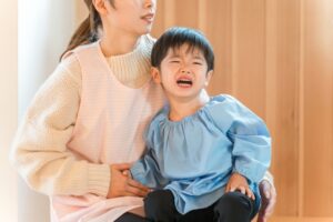 泣く子どもと困惑する保育士