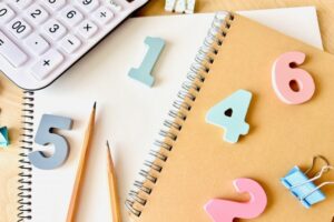 電卓と筆記具と数字の画像